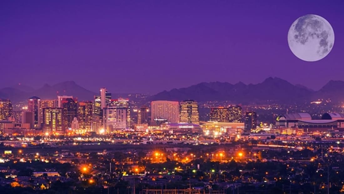 Phoenix skyline at night under a full moon